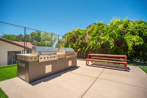 a picnic area with a barbecue grill and a bench at Acacia Gardens, Albuquerque, NM, 87111